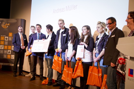 Landrat Andreas Müller freut sich mit dem Gewinnerteam vom CJD Siegen-Wittgenstein über die gute Idee von „WAS Wittgensteiner Autoschoner“. Ihr Produkt „Flink“ erleichtert Familien mit kleinen Kindern und älteren Menschen das Aussteigen in engen Parklücken.