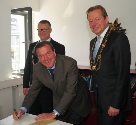 Altkanzler Gerhard Schröder ist der aktuellste Neuzugang im Goldenen Buch der Stadt Siegen. Bei seinem Eintrag wurde er flankiert von Dr. Martin Hill, Präsident des Rotary Clubs Siegen (li.) und Bürgermeister Steffen Mues. Foto: Stadt