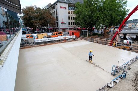Die Siegbrücke ist betoniert! An nur einem Tag wurde am Donnerstag, 18.09.2014, die zweiwöchige mühsame Arbeit der Eisenflechter unsichtbar. Ca. 85 Tonnen Stahl, die als Bewehrung für die Tragfähigkeit der Siegbrücke garantieren, wurden mit ca. 390 m3 Beton ummantelt und bedeckt. Die Betonmasse wurde an einem Tag auf einer Fläche von ca. 620 m2 in einer mittleren Stärke von 80 cm eingebaut. Die Betonpumpe, die den Beton aus den Betonfahrzeugen in die Brückenschalung pumpt, hat eine Ausladung von 42 m.