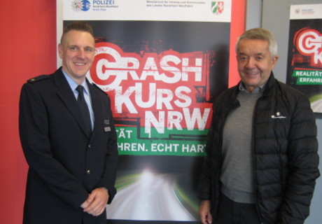  Polizeirat Helge Ammermann mit dem Vertreter der Kreisverkehrswacht, Michael Wulf vor dem Plakat der Veranstaltung. Foto: Polizei