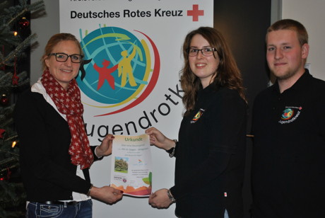 v.l.: Stadtmitarbeiterin Frau Ihlenfeld übergibt das Baumzertifikat an Melanie Graf und Maik Neeb vom Jugendrotkreuz (Foto: DRK)