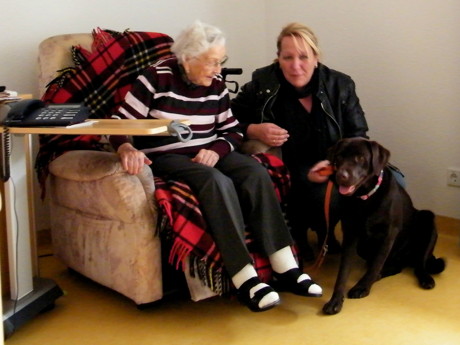 Labrador- Hündin Betty mit Frauchen Simone Schneider zu Besuch bei einer Bewohnerin im Sophienheim (Foto: Malteser)