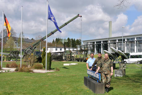 Freuen sich schon auf den Tag der offenen Tür, (v.r.) die Oberstleutnante Lars Gehlhaar und Lars Hoffmann sowie Oberstabsfeldwebel Peter Hanke. Im Hintergrund laufen bereits Aufbauarbeiten ersterer Exponate. (Foto: Daniel Heinen)
