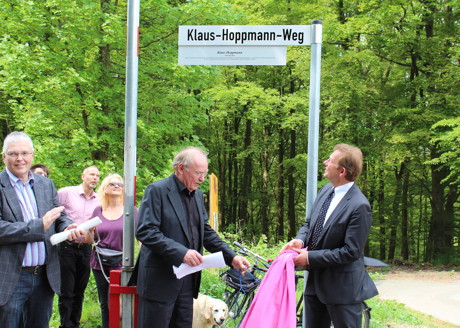 Bürgermeister Steffen Mues und der Vorsitzende der Hoppmann-Stiftung, Wolfgang Belitz, enthüllten jetzt das neue Straßenschild zum „Klaus-Hoppmann-Weg“. (Foto: Stadt Siegen)