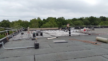 Ein Arbeitsplatz in luftigen Höhen. Bevor das Dach saniert und gedämmt werden kann, müssen die alten Baustoffe beseitigt werden.
