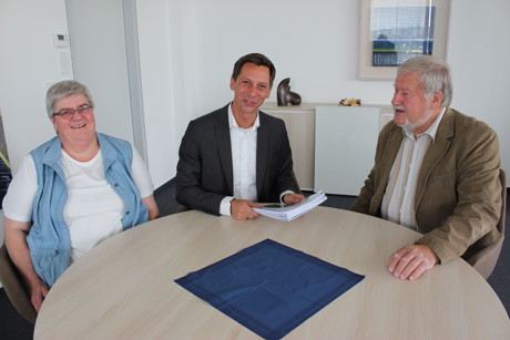 Landrat Andreas Müller (Mitte) überreicht den Bewilligungsbescheid über das Förderdarlehn der NRW Bank an Manfred Oerter, ehrenamtlicher Geschäftsführer der Autismus Wohnanlage Netphen. Mit dabei: Astrid Pohl von der Wohnungsförderung des Kreises. (Foto: Kreis)