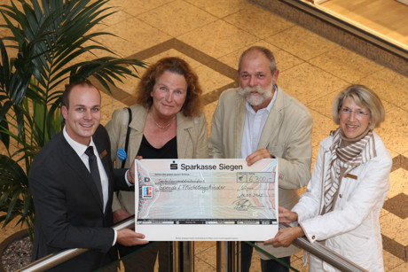 Spendenübergabe im Rahmen der großen Bücheraktion in der City-Galerie. Im Bild von links: Center Manager Patrick Homm, Angelika Gruß (Unicef), Reimund Ditsche (Stichting for school an life) sowie Gabriele Fleschenberg (Soroptimists Siegen).