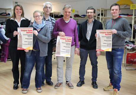 Im neueröffneten Laden des Ökumenischen Netzwerks Wilnsdorf warben die Veranstalter fürs Benefizkonzert. V.l.n.r.: Wilnsdorfs Bürgermeisterin und Schirmherrin Christa Schuppler, Sonja Sabel und Reiner Füchtenschnieder (beide Ökumenisches Netzwerk Wilnsdorf), „Akzente“-Dirigent Michael Blume, Pfarrer Christoph Otminghaus sowie Volker Arns, Chorleiter der „Gemischten Stimmen BIGGEsang“.