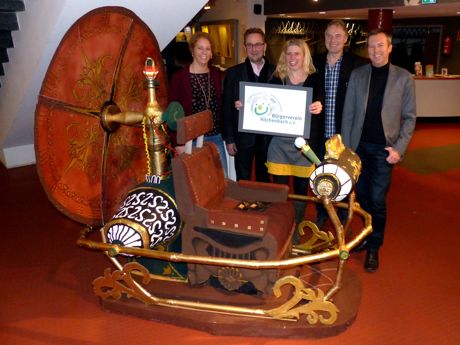 Nina Ehrler, Hans-Peter Hasenstab, Carina Schellenberg, Hans-Jürgen Klein und Olaf Kemper stellten das Logo des Bürgervereins mit einem lächelnden Gesichtbei der Zeitmaschine im Viktoria-Kino in Dahlbruch vor. (Foto: Bürgerverein)
