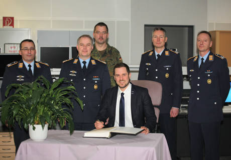 Obligatorischer Gästebucheintrag von Bürgermeister Henning Gronau (vorn) im Einsatzgebäude in der Hachenberg-Kaserne. (v. l.) Der Leiter des Systemzentrums 25, Oberstleutnant Michael Jäger, der Standortälteste und Kommandeur des Einsatzführungsbereich 2, Oberstleutnant Lars Hoffmann, der Einsatzführungsstabsoffizier, Major Thorsten Thielke, der stellvertretende Kommandeur und Leiter der Einsatzgruppe, Oberstleutnant Jörg Wagener sowie der Leiter des Lehr- und Verfahrenszentrums, Oberstleutnant Leif Nielsen. (Fotos: Daniel Heinen)