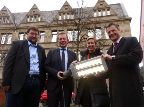 Die LED-Lampe im Einsatz vor dem Rathaus zeigt, wie hell die Dioden leuchten: Zum Projektabschluss hatten Dr. Catharina Friedrich, Leiterin des Regionalzentrums Sieg des RWE-Verteilnetzbetreibers Westnetzund Peter Imhäuser, Leiter der RWE-Kommunalbetreuung Region Siegen, eine LED-Leuchte für Bürgermeister Steffen Mues und Volker Kalender als Energiebeauftragten der Stadt Siegen (links) mitgebracht. (Foto: Stadt Siegen)