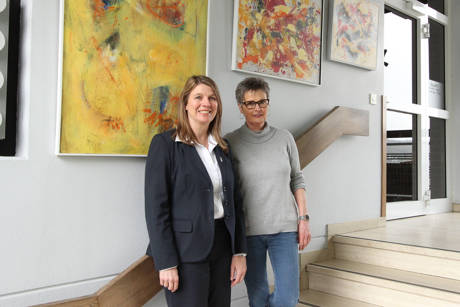 Die Anzhäuser Künstlerin Marion Berger (r.) stellt zurzeit im Wilnsdorfer Rathaus aus, Bürgermeisterin Christa Schuppler durfte als erste die dynamisch wirkenden Bilder sehen. (Foto: Gemeinde Wilnsdorf)