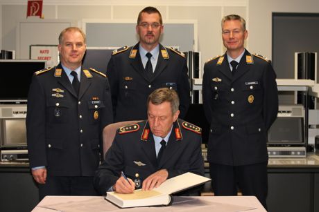 Der Kommandeur des Zentrum Luftoperationen, Generalleutnant Joachim Wundrak (vorn), trägt sich im „Control and Reporting Center“ in das Gästebruch des Einsatzführungsbereich 2 ein. (Hinten v. l.) Oberstleutnant Lars Hoffmann, Major Thorsten Thielke und Oberstleutnant Jörg Wagener. Foto: Heinen/Luftwaffe