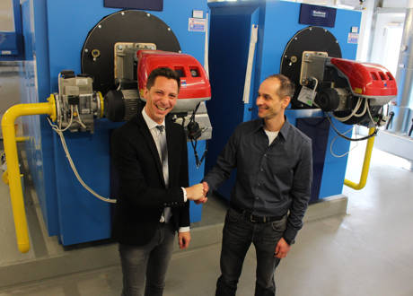 Landrat Andreas Müller (l.) und Klimaschutzmanager Gunter Stegemann vor den Heizungsbrennern in der 15. Etage des Kreishauses. Durch die Sanierung des Gebäudes ab dem Jahre 2008 wurde alleine der Gasverbrauch um 80 Prozent gesenkt. (Foto: Kreis Siegen-Wittgenstein)