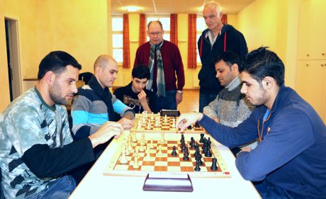 Integration mit dem Spiel der Könige: Über das Schachspiel haben sich Werner Weber, Wolfgang Petri (hinten) die al Doukhi Familie und Yamen el Medyeb (hinten rechts) kennengelernt. Foto: Gemeinde
