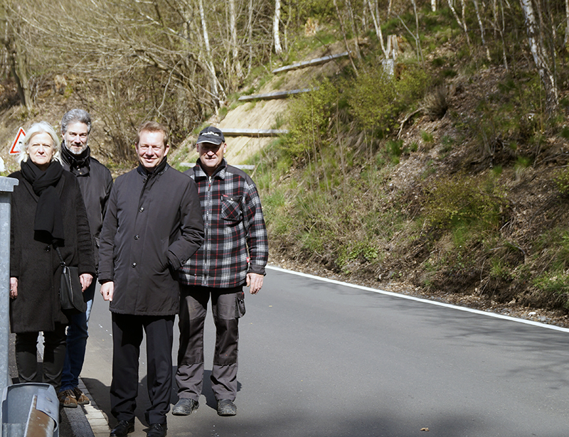 Helge Klinkert (Kreisdezernetin Straßenbau), Oliver Alt (Projektleiter Straßen.NRW), Bürgermeister Steffen Mues und Jörg Ottersbach (Schachtmeister Firma Fink-Stauf) auf der sanierten Straße.
