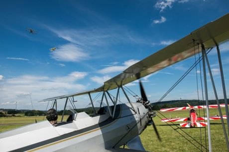 Doppeldecker, Doppeldecker, Doppeldecker – am Boden und in der Luft. Im Vordergrund der älteste noch flugfähige “Stieglitz” der Welt. Thomas Holz lässt den Motor warmlaufen. Foto: Elfi Jung
