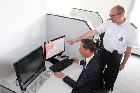 Thomas Jung (r.), Leiter der Kreisleitstelle, erläutert Landrat Andreas Müller die MoWaS-Software, mit der auch die App NINA angesteuert werden kann.